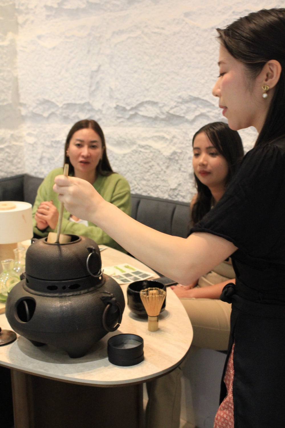 A Chotto Matcha host demonstrates tea preparation to guests